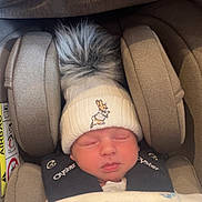 Hugo is registered to the contest to win money with this photo: baby, infant, sleeping, car_seat, hat, pom_pom, knit_hat, bunny, blanket, boat_pattern, cozy, child, cute, peaceful, face, headwear, soft, wrapped, indoors, resting