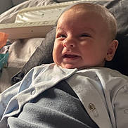 Hugo is registered to the contest to win money with this photo: baby, bed, blanket, candid, child, cozy, cute, expression, face, furniture, home, indoors, infant, newborn, pajamas, portrait, room, sleepwear, smiling, soft_lighting