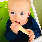 Adfwef joined the competition — help win amazing prizes! baby, child, infant, face, eyes, blue_eyes, smiling, eating, snack, food, hands, high_chair, indoor, portrait, sitting, navy_clothing, green_background, close_up, adorable, photography