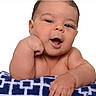 baby, infant, child, portrait, smiling, happy, face, eyes, mouth, hands, arm, blanket, patterned_blanket, indoors, closeup, sitting, lying_down, adorable, brown_hair, photography