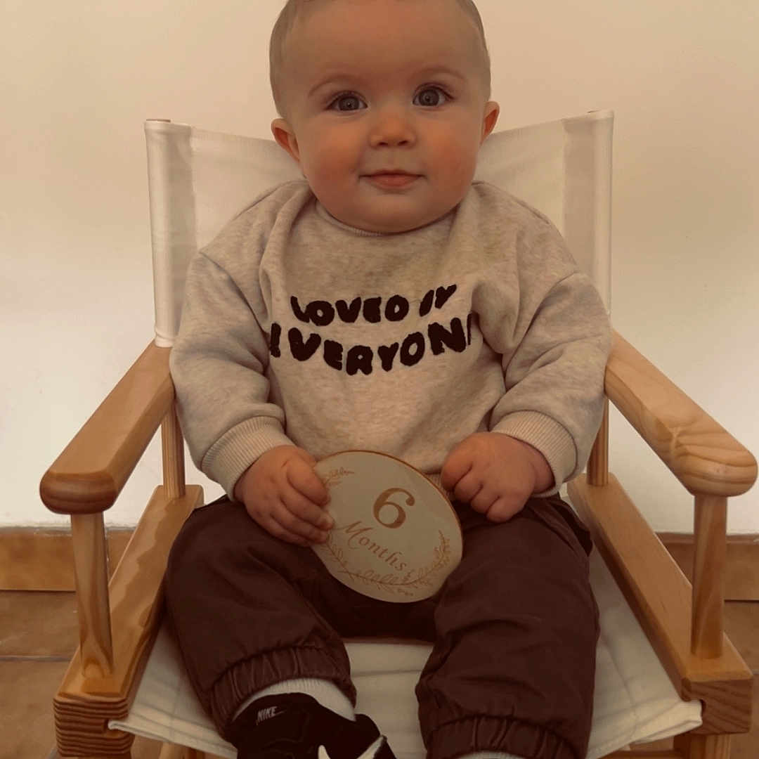 Isaac participe au concours pour gagner de l'argent avec cette photo : baby, chair, child, clothing, cute, eyes, face, floor_tiles, hands, indoor, infant, milestone_card, nike, portrait, sitting, smiling, sneakers, sweatshirt, wooden_chair, young_child