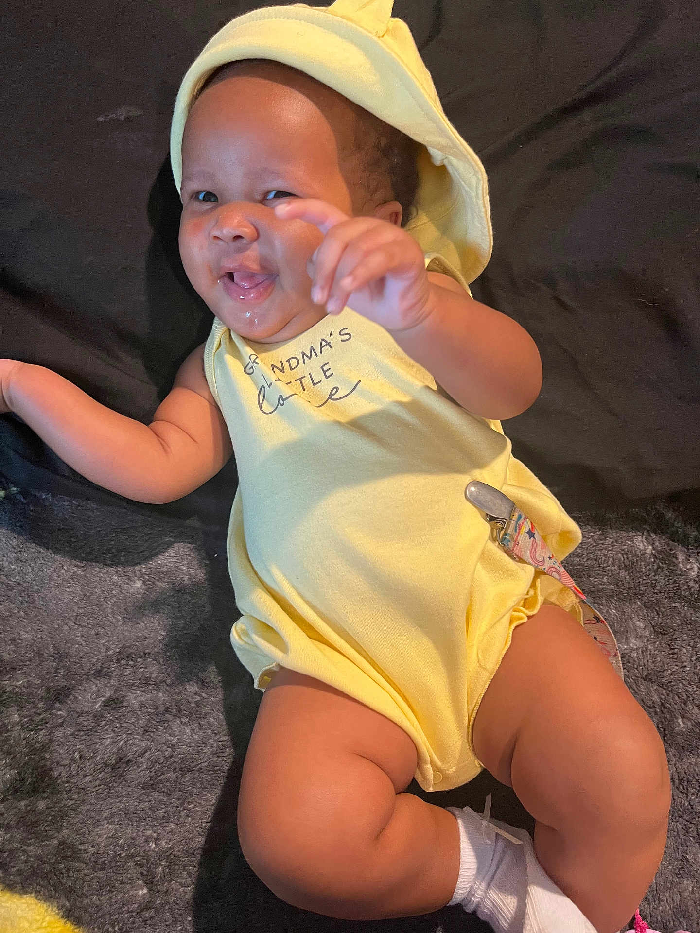 Jaylani joined the competition — help win amazing prizes! baby, infant, yellow_outfit, hat, smiling, reaching_hand, lying_down, blanket, soft_texture, cute, happy, chubby_legs, white_socks, indoors, child, portrait, playful, toddler, one_person, casual_clothing