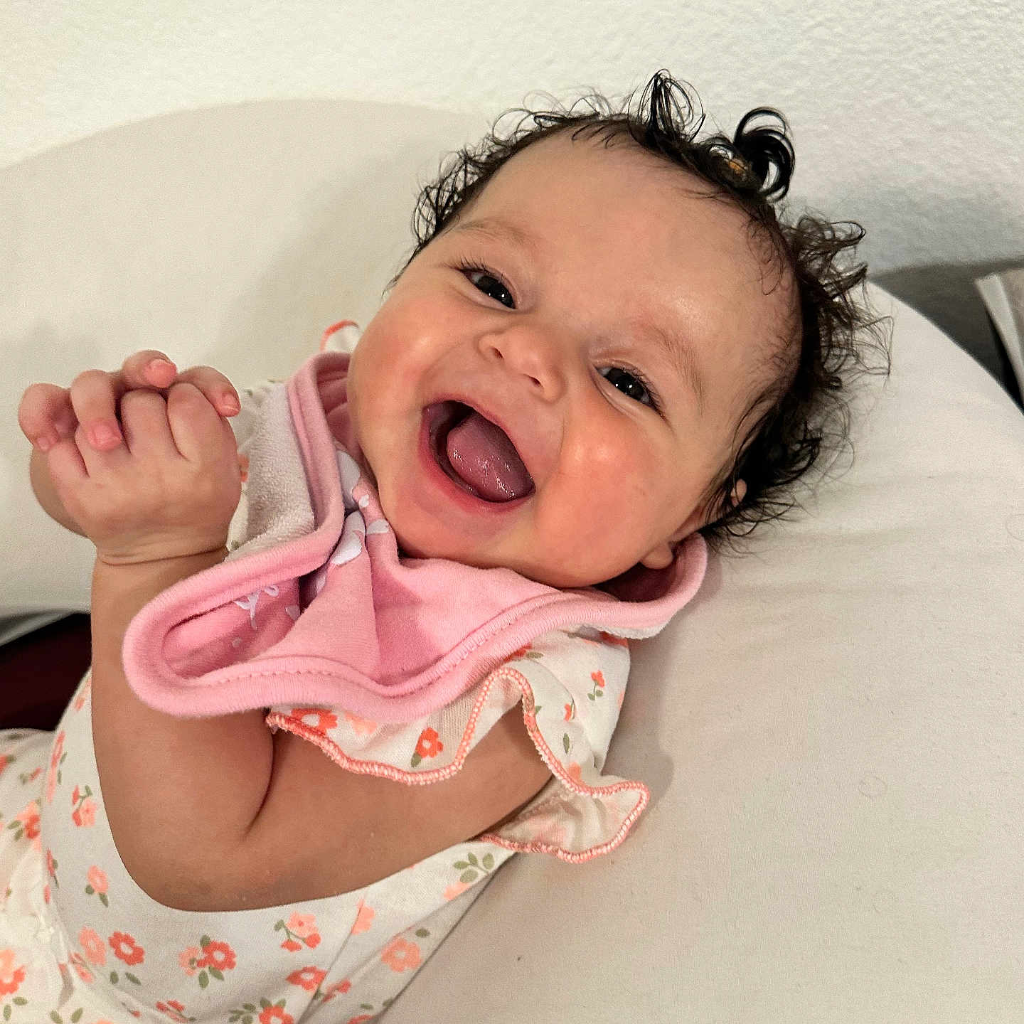 Zeina-Pierina joined the competition — help win amazing prizes! baby, child, closeup, curly_hair, cushion, cute, face, floral_clothing, hand, happy, indoors, infant, laughing, lying_down, person, pink_bib, portrait, skin, smiling, white_background