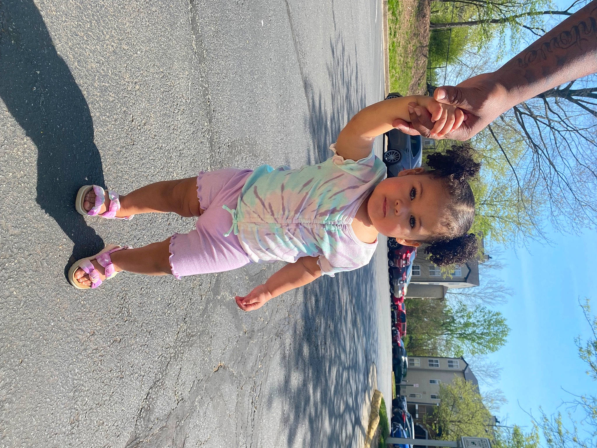 Leya is registered to the contest to win money with this photo: asphalt, child, facial_expression, fun, grass, happy, human_leg, leisure, people_in_nature, person, plant, play, recreation, sidewalk, sky, thigh, toddler, tree, vacation, water