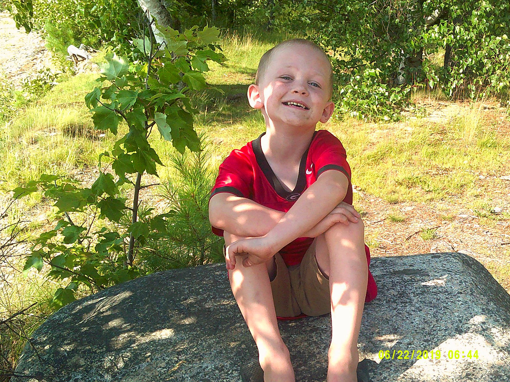 Dwight is registered to the contest to win money with this photo: adaptation, botany, child, fawn, fun, grass, joy, leaf, leg, leisure, person, plant, sitting, smile, summer, toddler, tree, vacation