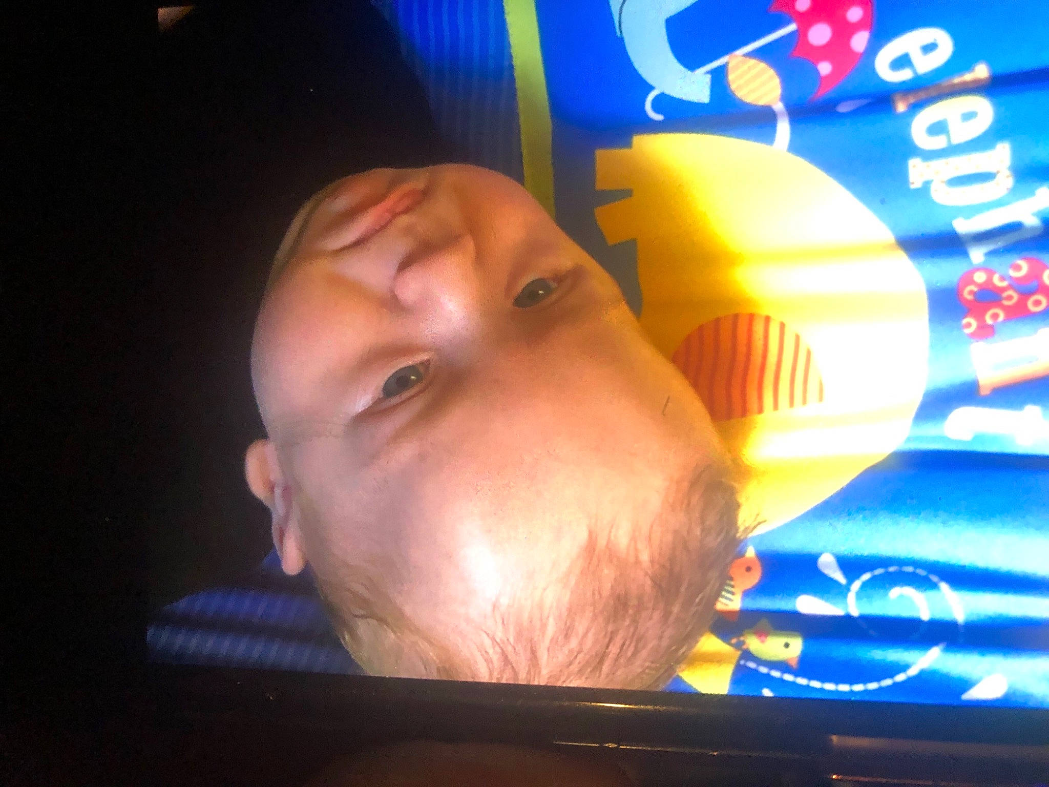 Roy is registered to the contest to win money with this photo: advertising, baby, child, display_device, electric_blue, eyelash, font, fun, games, gas, logo, neon, night, nose, orange, person, plastic, recreation, signage, sorrow