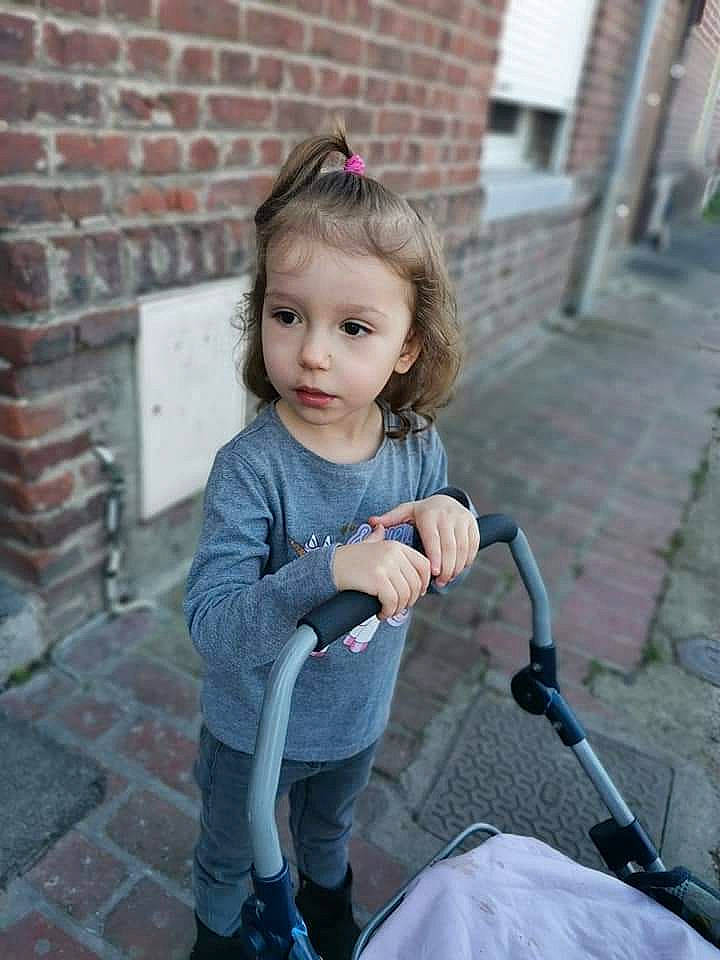 Cassy a rejoint le concours — aidez-le/la à gagner de superbes lots ! baby_carriage, baby_toddler_clothing, beauty, bicycle_handlebar, bicycle_tire, brick, brickwork, child, dress, eye, grey, lip, microphone, person, pink, recreation, sitting, skin, sleeve, street_fashion