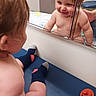 baby, infant, child, mirror, reflection, smiling, happy, indoor, portrait, tummy_time, diaper, bare_chest, sock, pacifier, changing_table, nursery, playful, face, person, home