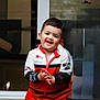 Luis Felipe a rejoint le concours — aidez-le/la à gagner de superbes lots ! toddler, child, smiling, happy, clapping, jacket, red, white, black, reflection, glass, window, standing, portrait, indoor, person, cute, young, casual_clothing, sporty