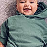baby, child, smiling, green_hoodie, carpet, happy, infant, cute, portrait, casual_clothing, indoor, young_child, sitting, person, face, head, human, apparel, expression, joyful