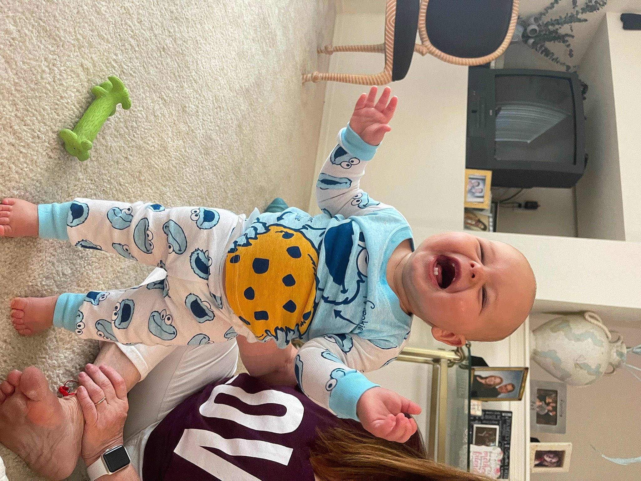 Hudson is registered to the contest to win money with this photo: arm, audio_equipment, baby, baby_products, child, comfort, finger, foot, fun, happy, leg, pattern, person, room, smile, snapshot, stuffed_toy, t_shirt, thumb, toddler