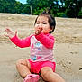 Sofia is registered to the contest to win money with this photo: toddler, child, beach, sand, pink_clothing, happy, playing, outdoor, nature, water, smiling, shorts, footwear, grass, sky, casual, fun, summer, clapping, young_child