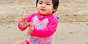 Sofia is registered to the contest to win money with this photo: toddler, child, beach, sand, water, pink_clothing, happy, playing, outdoor, nature, smiling, feet, sitting, summer, casual, fun, young, people, kids, clapping