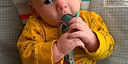 Sunnie is registered to the contest to win money with this photo: baby, infant, pacifier, yellow_shirt, denim_pants, hands, face, blue_eyes, indoor, sitting, cute, child, clothing, background, warning_label, colorful, closeup, expression, young, comfort