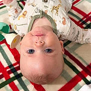 Sunnie is registered to the contest to win money with this photo: animal_print, baby, blue_eyes, child, cozy, cute, face, hand, head, indoor, infant, lying_down, onesie, person, plaid_blanket, portrait, skin, soft_fabric, toy, young_child