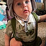 baby, blue_eyes, candid, carpet, casual, child, curious, cute, expression, face, footwear, green_clothing, hat, indoor, infant, person, portrait, sitting, suspenders, young_child