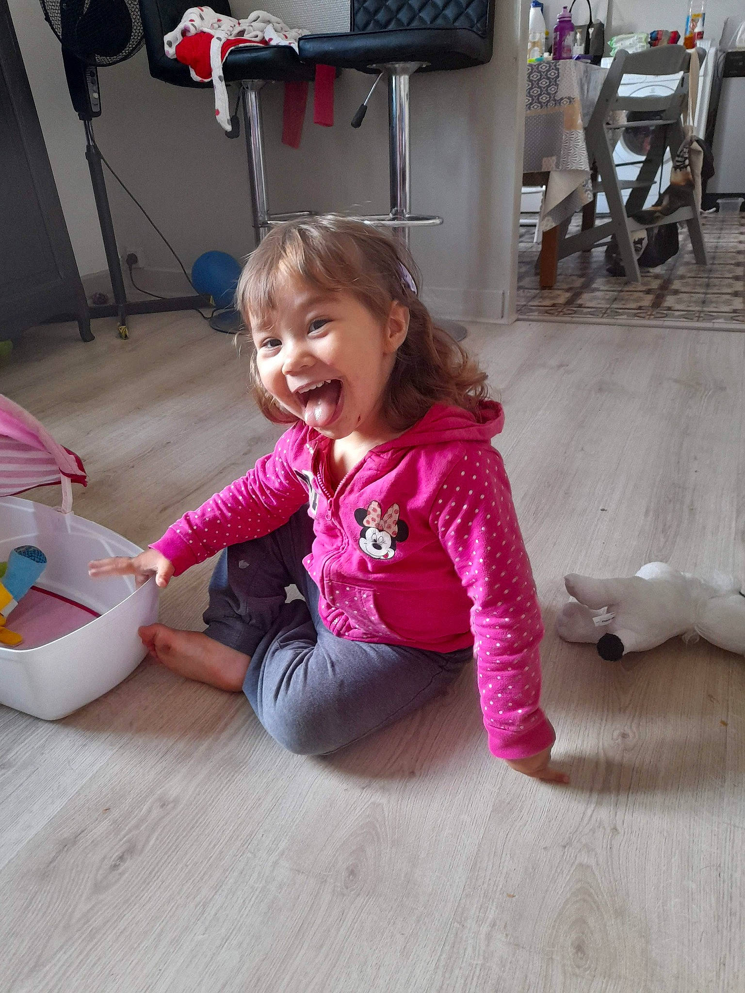 Julie participe au concours pour gagner de l'argent avec cette photo : baby_toddler_clothing, chair, child, facial_expression, floor, flooring, fun, happy, hardwood, joint, leg, leisure, person, pink, skin, smile, sneakers, sock, toddler, white