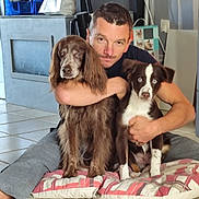 Aiko participe au concours pour gagner de l'argent avec cette photo : man, dog, puppy, floor, cushion, indoor, tile_floor, hugging, brown_dog, white_and_brown_dog, blue_eyes, pet, casual_clothing, home, furniture, sitting, portrait, animal, person, companion