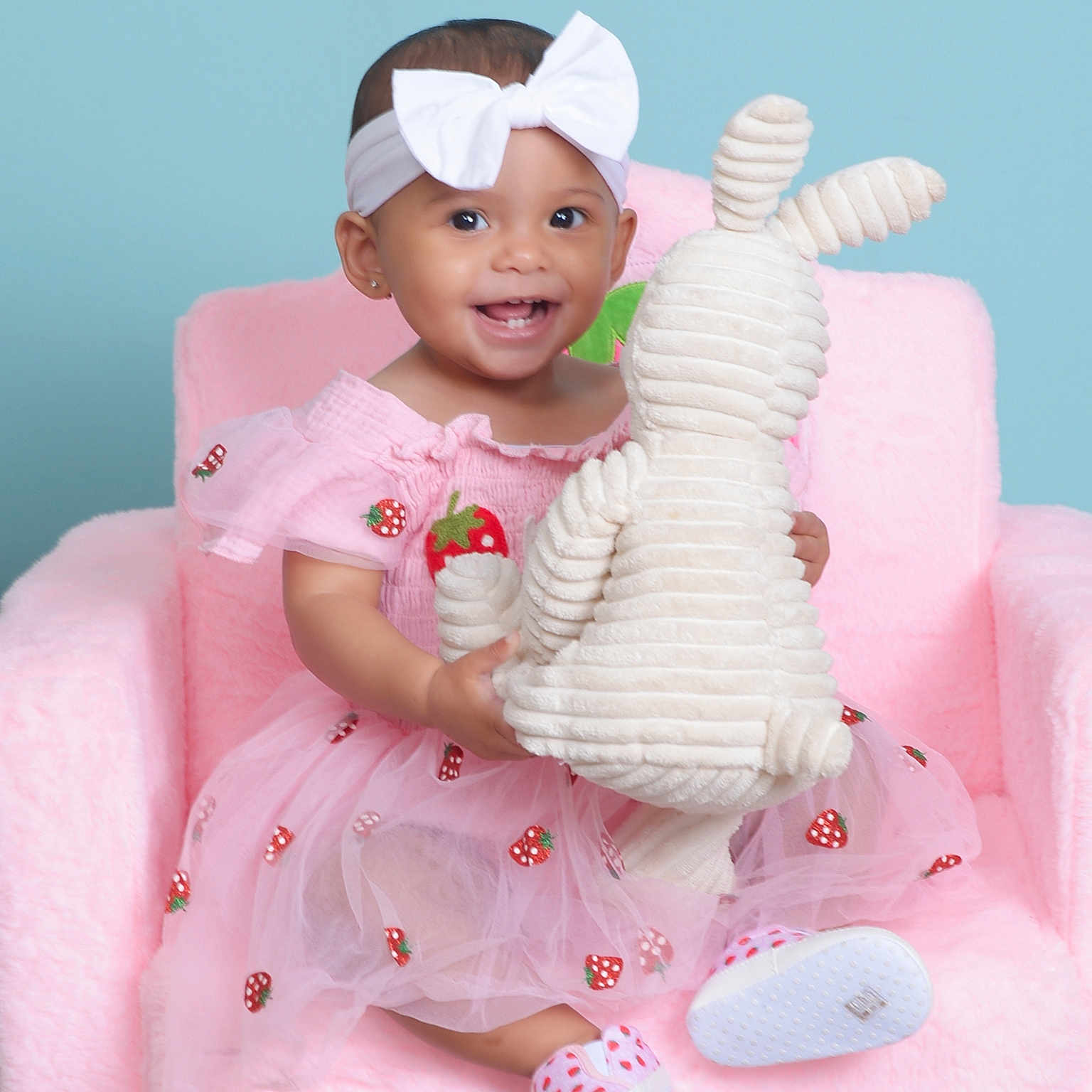 Rumiyah joined the competition — help win amazing prizes! baby, child, pink_dress, headband, white_bow, plush_toy, bunny, chair, smiling, cute, happy, indoor, portrait, footwear, baby_shoes, soft_texture, pastel_colors, toddler, female, studio_photo