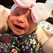 Everlee is registered to the contest to win money with this photo: baby, smiling, pink_bow, hat, floral_clothing, blanket, infant, cute, happy, face, portrait, child, soft_texture, cozy, indoor, newborn, wrapped, headwear, person, closeup