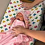 baby, infant, pink_towel, hooded_towel, duck_pattern, changing_pad, hands, care, soft_fabric, newborn, cute, wrapped, child, indoor, person, comfort, skin, expression, resting, cozy