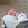 newborn, baby, sleeping, orange_hat, blanket, metal_bucket, wooden_floor, cozy, infant, soft_light, knit_blanket, peaceful, wrapped, cute, indoors, portrait, resting, small, child, baby_clothes