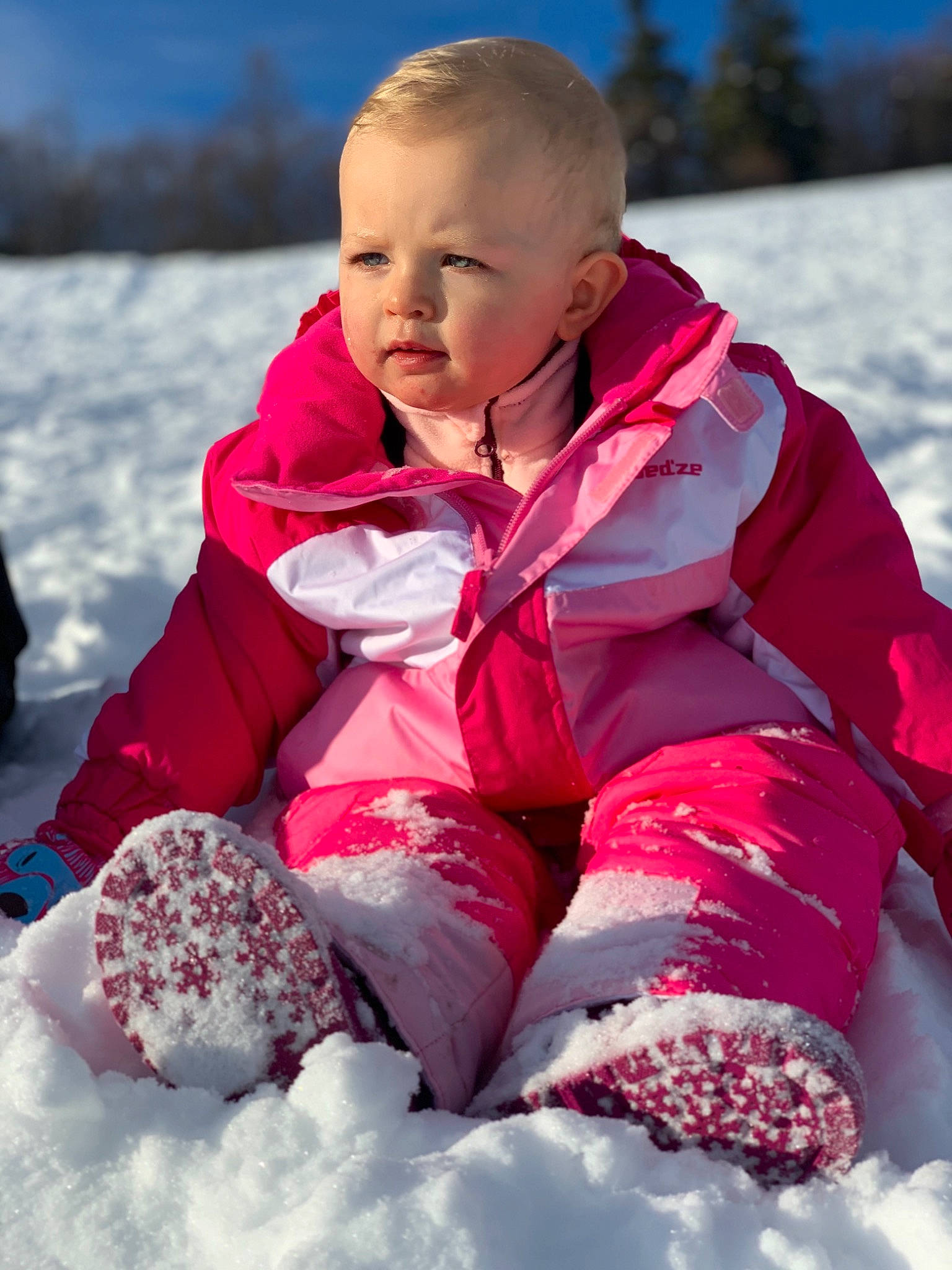 Victoria a rejoint le concours — aidez-le/la à gagner de superbes lots ! baby_toddler_clothing, boot, cheek, child, freezing, glacial_landform, glove, hood, ice, ice_cap, jacket, outerwear, person, pink, play, playing_in_the_snow, shoe, sitting, snow, toddler