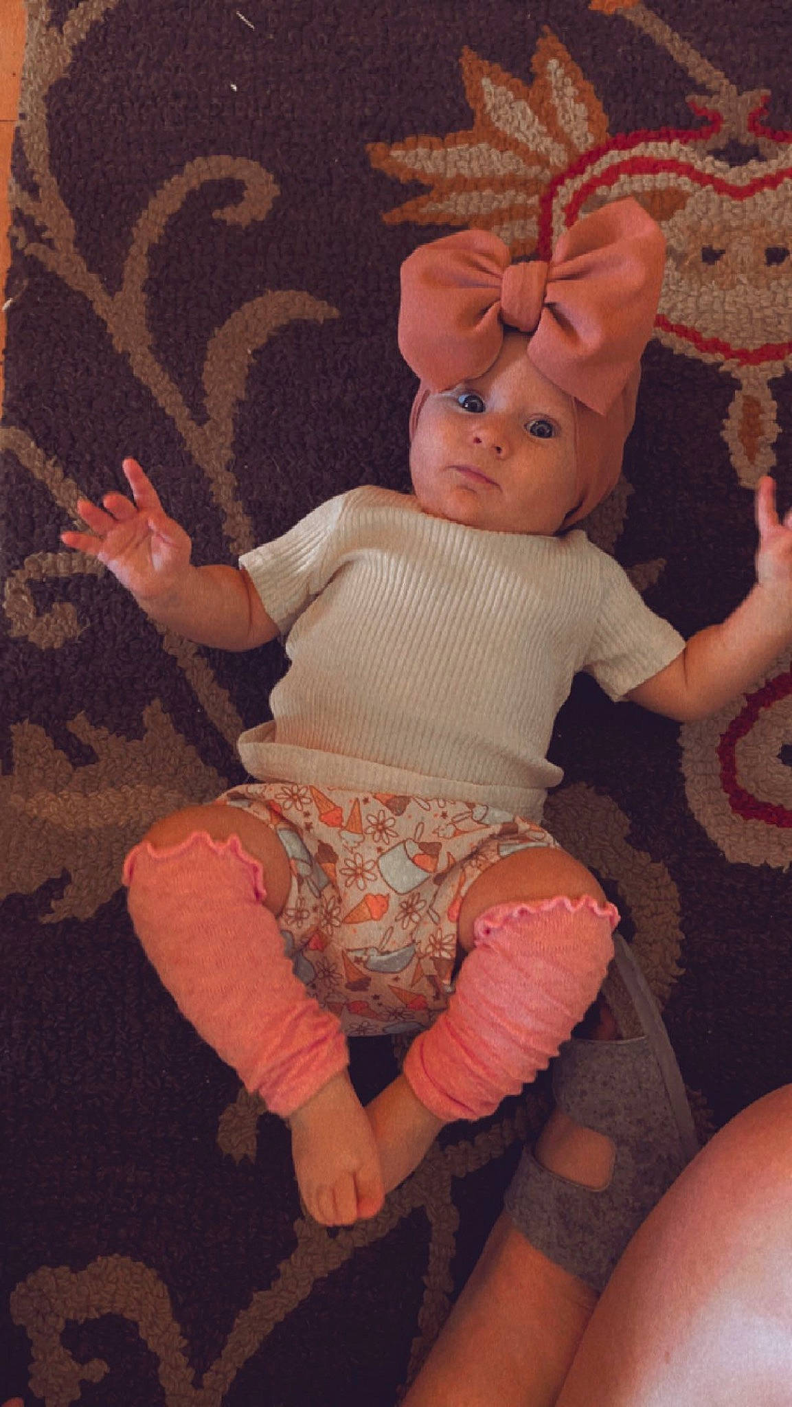 Maeve is registered to the contest to win money with this photo: baby_toddler_clothing, child, doll, finger, headwear, human_leg, joint, leg, linens, magenta, pattern, peach, person, pink, shorts, sitting, textile, thigh, thumb, toy