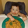 baby, child, high_chair, eating, food, rice, noodles, plate, messy, smiling, face, hands, indoor, portrait, sitting, dinner, meal, feeding, infant, home