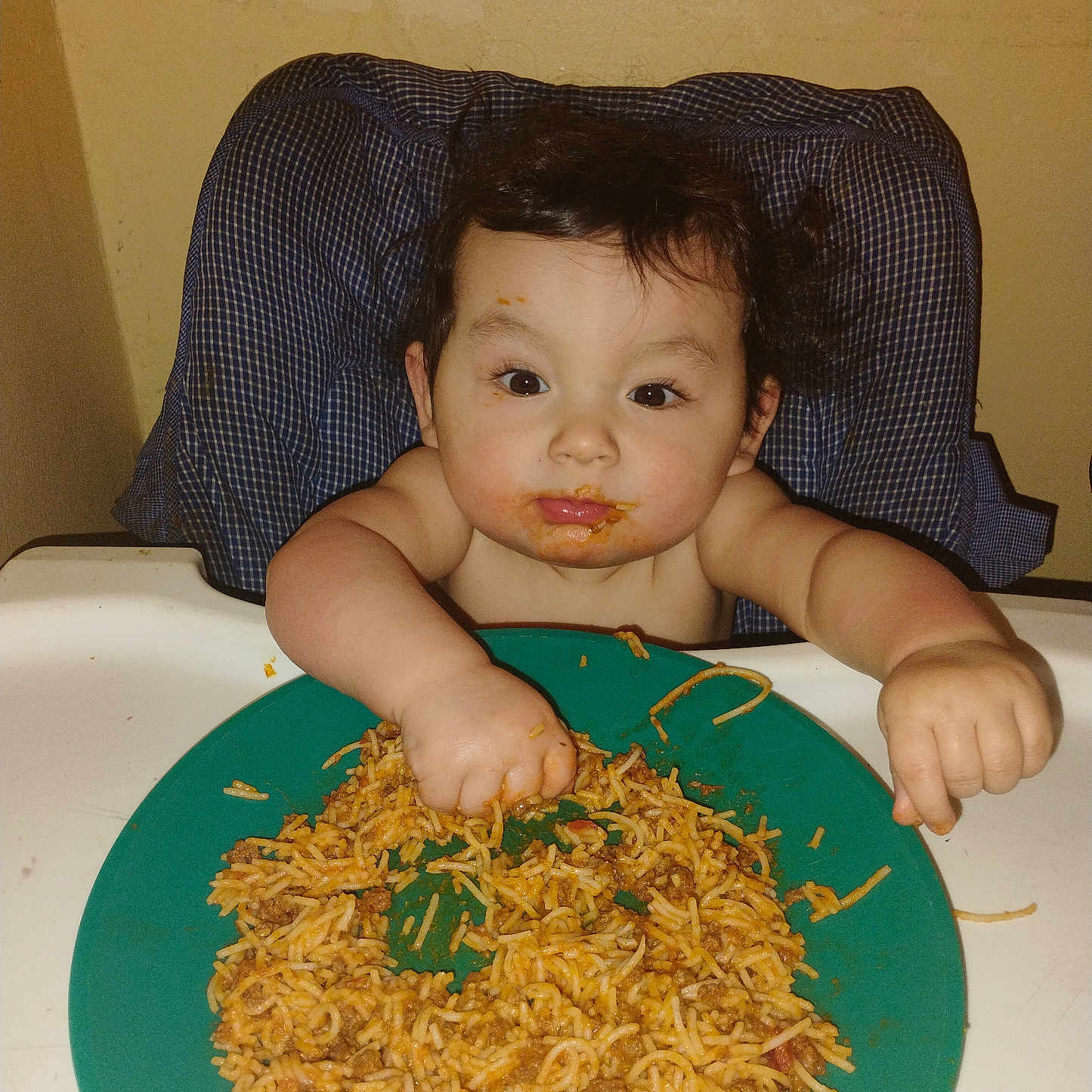 Alexander joined the competition — help win amazing prizes! baby, child, high_chair, eating, food, rice, noodles, plate, messy, smiling, face, hands, indoor, portrait, sitting, dinner, meal, feeding, infant, home