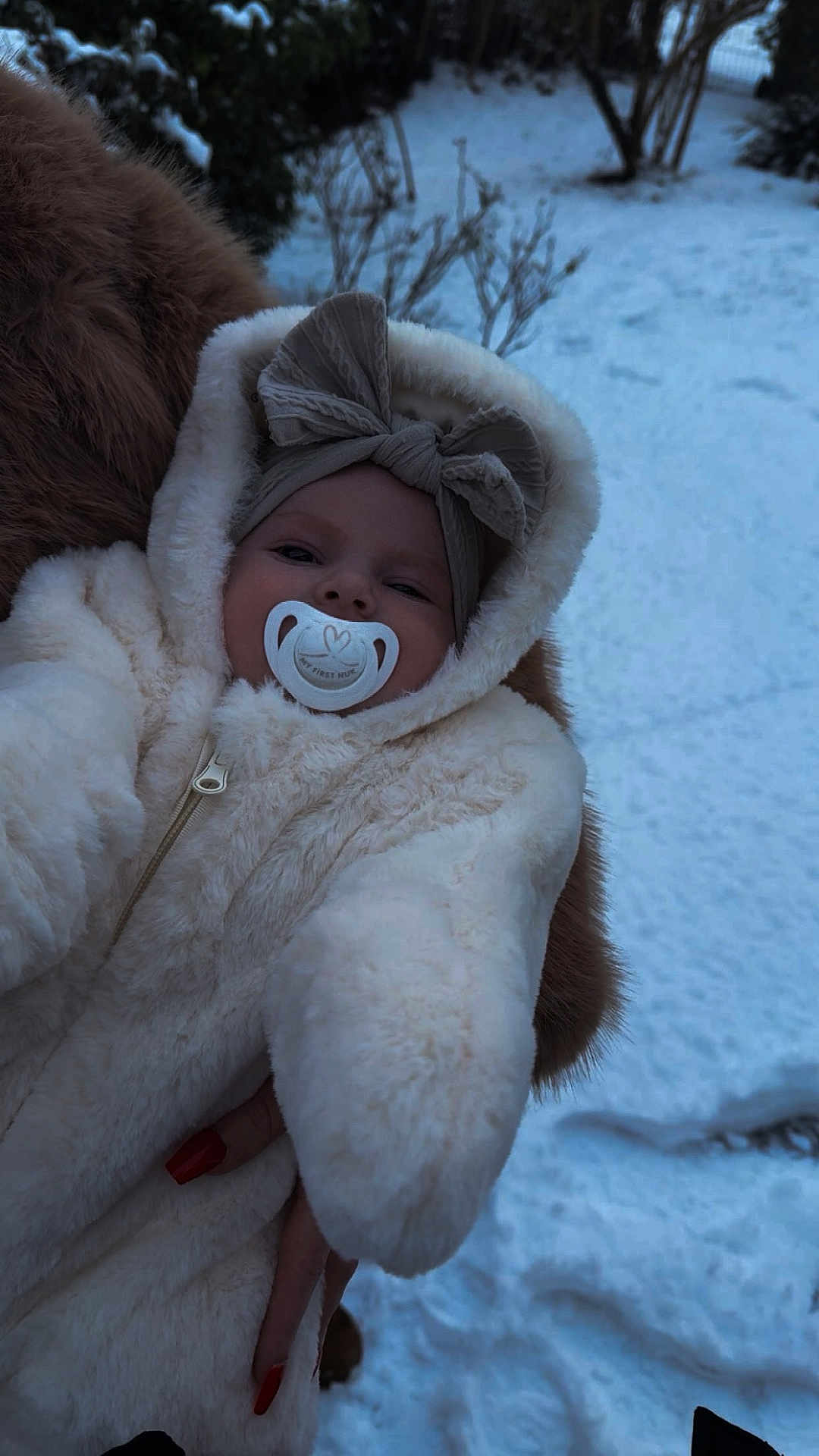 Tiyanna a rejoint le concours — aidez-le/la à gagner de superbes lots ! baby, child, pacifier, headband, bow, snow, winter, fur, onesie, outdoor, cold, hand, nail_polish, person, portrait, cute, warm_clothing, face, fur_coat, winter_clothing