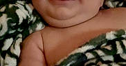 Jaxxon is registered to the contest to win money with this photo: baby, blanket, child, chubby, closeup, cozy, cute, expression, face, happy, indoor, infant, lying_down, portrait, relaxed, skin, smiling, tongue, warm, wrapped