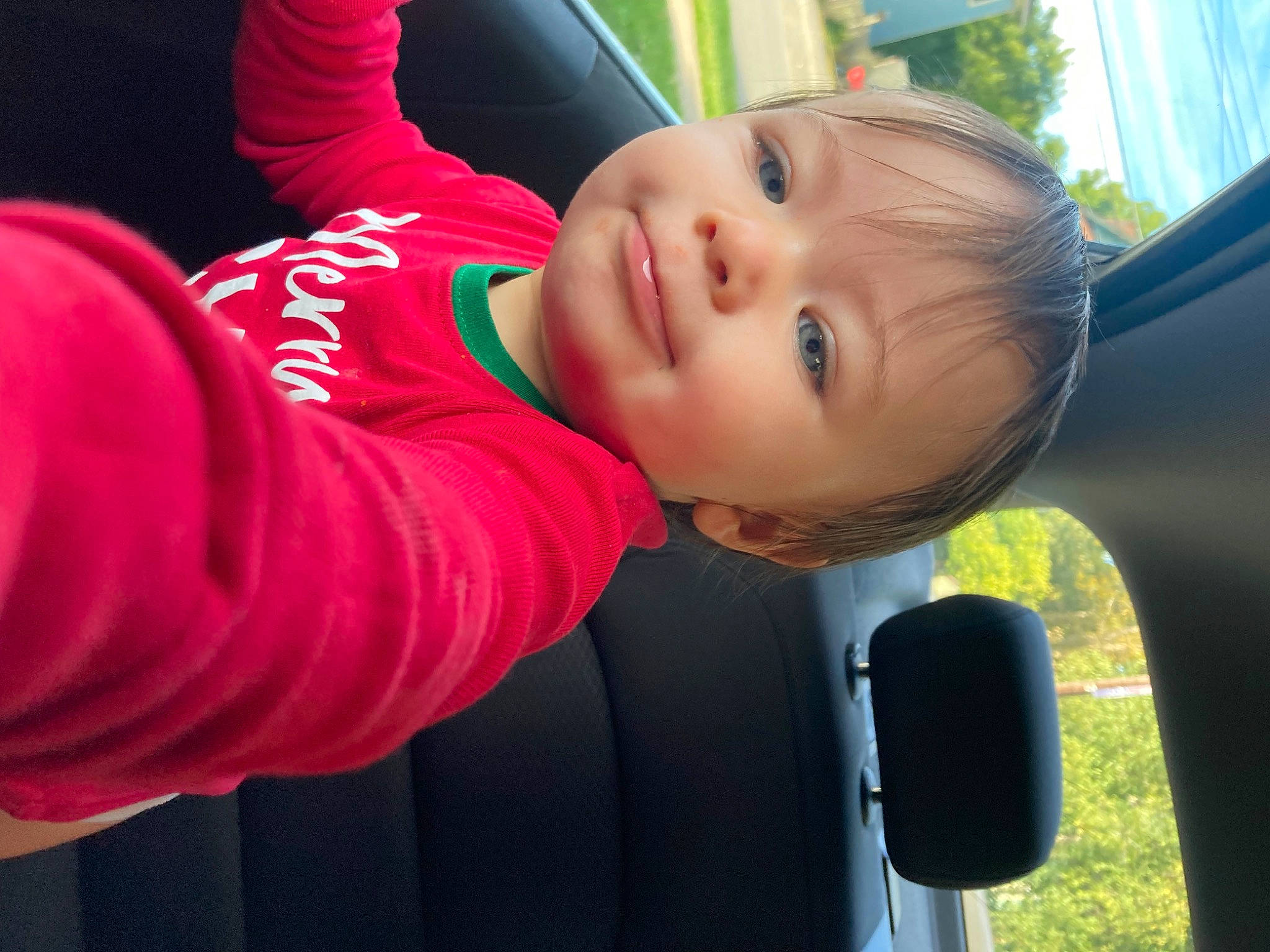 Avril is registered to the contest to win money with this photo: auto_part, automotive_exterior, automotive_mirror, baby, baby_toddler_clothing, car, car_seat, child, finger, fun, grass, happy, leisure, nose, person, smile, toddler, tree, vehicle, vehicle_door