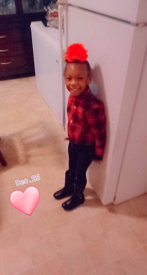 Carmen is registered to the contest to win money with this photo: baby_toddler_clothing, bonnet, cap, carmine, child, facial_expression, floor, flooring, heart, joy, love, maroon, material_property, organ, pattern, person, photograph, pink, red, standing