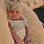 baby, infant, headband, bow, pillow, clothing, lace, patterned_pants, face, hands, cozy, soft, indoors, child, newborn, portrait, person, cute, resting, comfortable