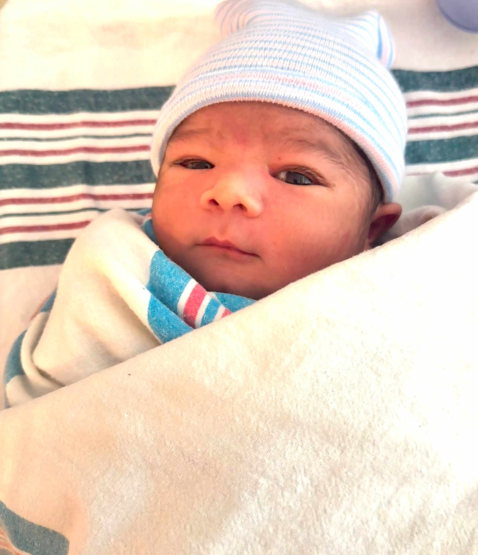 Zayan is registered to the contest to win money with this photo: newborn, baby, infant, wrapped, blanket, hat, hospital, face, eyes, cute, sleepy, soft, skin, portrait, closeup, child, newborn_baby, headwear, lying_down, indoors