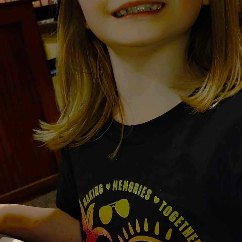 Hermaya joined the competition — help win amazing prizes! braces, casual_clothing, child, decorations, face, food, fries, hair, happy, indoor, person, plate, portrait, restaurant, seat, smiling, table, tshirt, warm_lighting, young