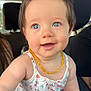 baby, child, smiling, blue_eyes, hair_clip, amber_necklace, floral_dress, car_interior, seat, cute, portrait, infant, happy, person, skin, young_child, summer_clothing, closeup, indoors, natural_light