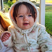 Mary joined the competition — help win amazing prizes! baby, child, hooded_jacket, outdoor, sunlight, smiling, face, person, cute, infant, warm_clothing, nature, portrait, young_child, hand, grass, daylight, suburban, casual, happy