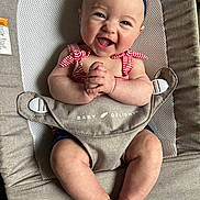 Spencer is registered to the contest to win money with this photo: apparel, baby, baby_product, baby_seat, blue_eyes, chubby_arms, chubby_legs, clasped_hands, closeup, cute, fabric, face, happy, headband, indoor, infant, person, red_stripes, seat, smiling