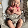 apparel, baby, baby_product, baby_seat, blue_eyes, chubby_arms, chubby_legs, clasped_hands, closeup, cute, fabric, face, happy, headband, indoor, infant, person, red_stripes, seat, smiling