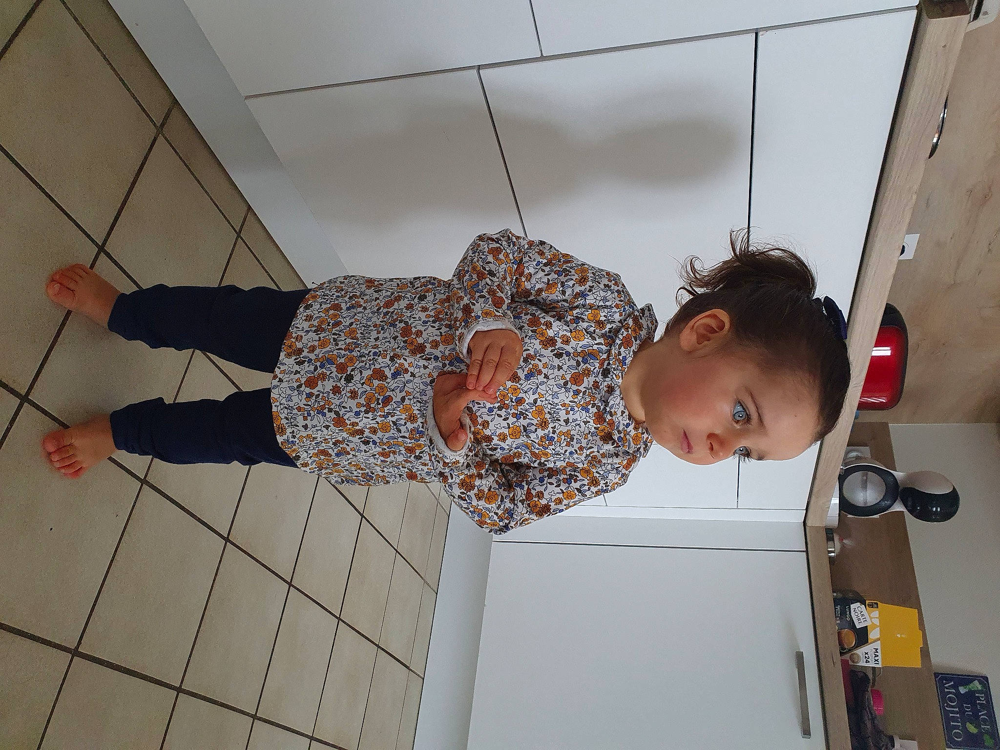 Lou participe au concours pour gagner de l'argent avec cette photo : ceiling, child, elbow, eyewear, fashion_design, flooring, fun, happy, human_leg, knee, leisure, line, pattern, person, room, sandal, thigh, toddler