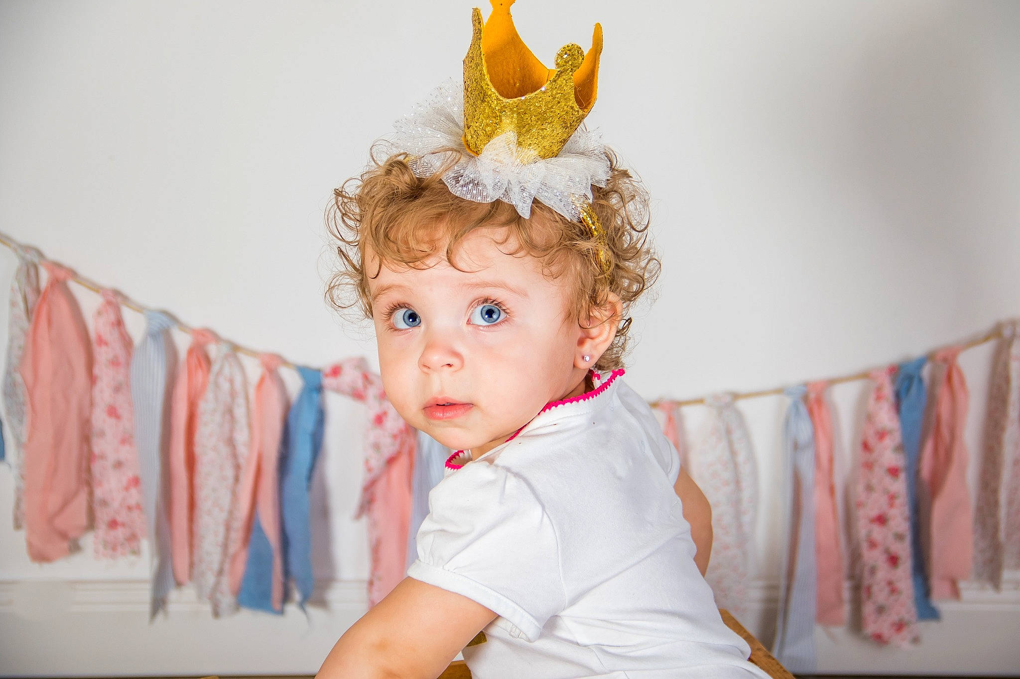 Cierra is registered to the contest to win money with this photo: baby, child, child_model, costume_accessory, costume_hat, crown, ear, fashion_accessory, fictional_character, hair_accessory, head, headgear, headpiece, party_hat, party_supply, person, portrait_photography, room, toddler, white