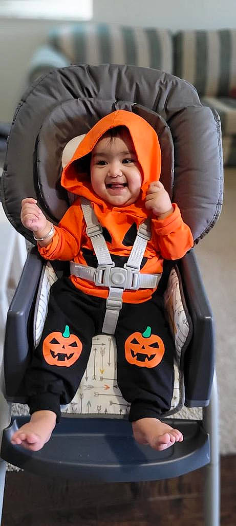 Prisha is registered to the contest to win money with this photo: auto_part, baby_carriage, baby_safety, baby_toddler_clothing, car_seat, child, comfort, fun, glove, happy, headwear, joy, orange, person, personal_protective_equipment, recreation, sitting, sleeve, smile, toddler