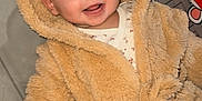 Inaya a rejoint le concours — aidez-le/la à gagner de superbes lots ! baby, child, hooded_coat, teddy_bear, smiling, happy, indoor, play_mat, toy, colorful, face, infant, cute, warm_clothing, person, young_child, cozy, childcare, baby_girl_or_boy, soft_texture