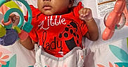 Phor'Ever is registered to the contest to win money with this photo: baby, infant, child, portrait, sitting, activity_center, toy, colorful, red_outfit, ladybug, bib, cat_bib, headband, smiling, wide_eyed, indoor, baby_seat, playtime, patterned_background, safe