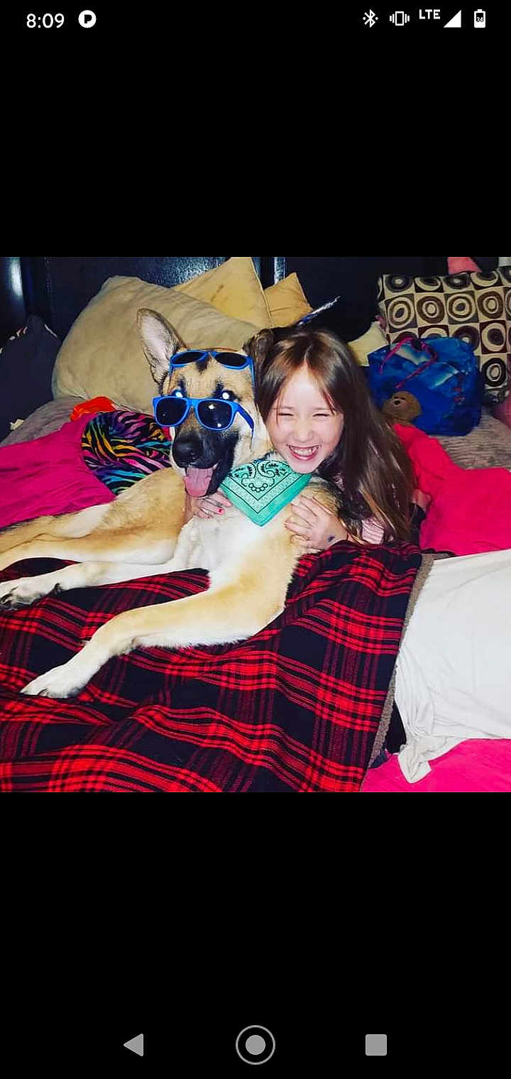 Ace joined the competition — help win amazing prizes! dog, child, girl, sunglasses, bandana, bed, blanket, pillow, smiling, happy, indoor, pet, friendship, playing, fun, casual, relaxed, cozy, animal, portrait