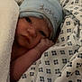 newborn, baby, infant, hospital, blanket, hat, face, person, bed, sheet, clothing, cute, skin, hand, lying_down, cozy, young_child, indoors, portrait, resting