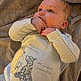 baby, infant, blanket, clothing, cute, face, hand, lying_down, person, portrait, soft_texture, toddler, winnie_the_pooh, yellow, blue, sleepwear, cozy, young_child, expression, indoor