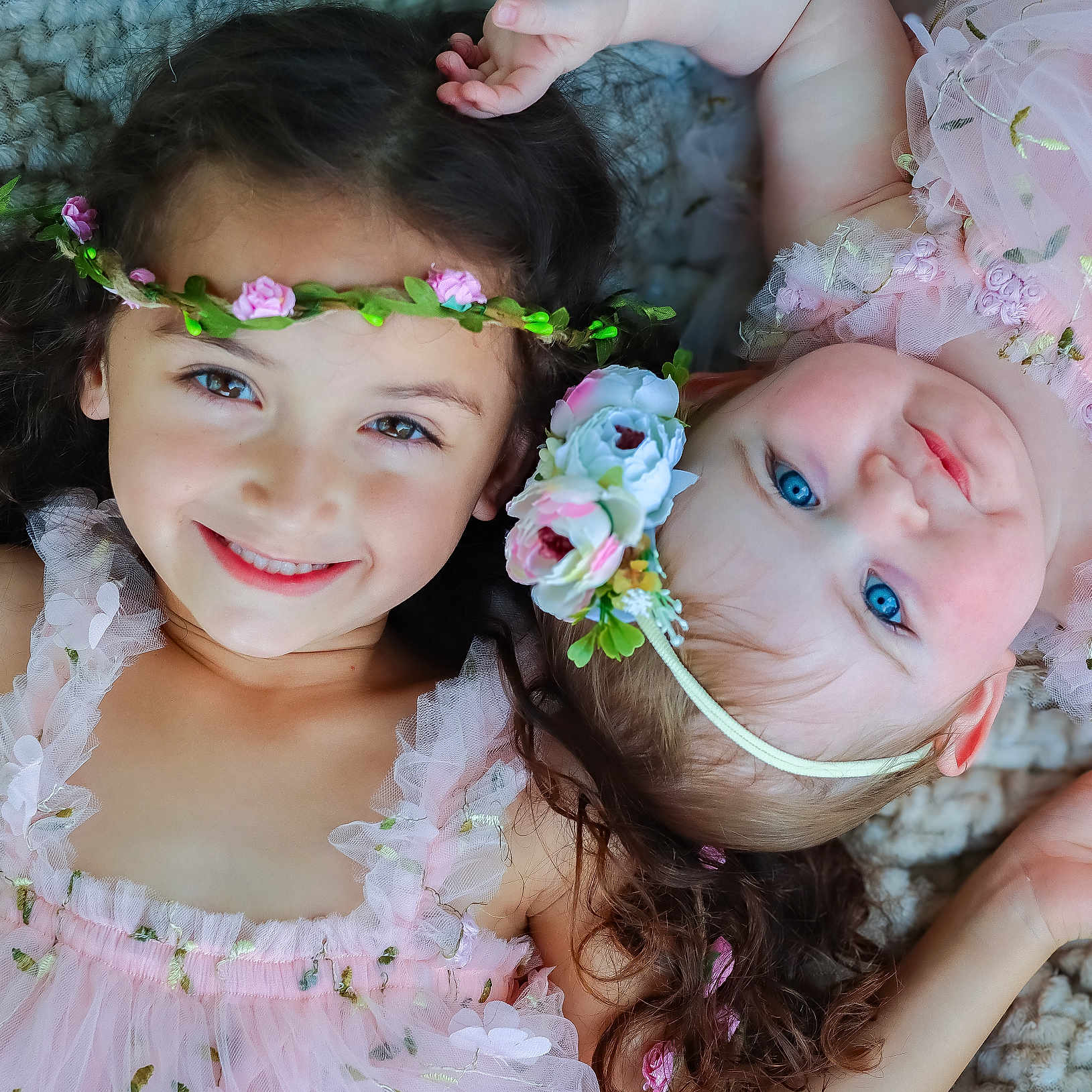 Emmie joined the competition — help win amazing prizes! baby, blue_eyes, child, closeup, curly_hair, cute, face, flower_crown, happy, headband, innocence, joy, laying_down, person, pink_dress, portrait, sibling, skin, smiling, toddler